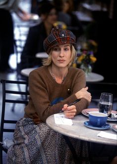 a woman sitting at a table with a cup and saucer