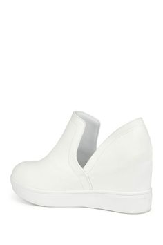 Add some freshness to your wardrobe with the Cardi sneaker by Journee Collection. This easy slip-on style shoe features a hidden wedge design with a round toe and platform bottom. The deep V side cut-outs add a unique touch and create an easy entry. Sizing: True to size. M=medium width. Round toe. Slip-on style. Split sides. Approx. 3" heel height. Approx. 3.5" shaft height, 11" opening circumference. ImportedThis item cannot be shipped to Canada. Spring Streetwear Platform Sneakers With Wedge Heel, Spring Wedge Sneakers With White Sole, Spring Synthetic Wedge Sneakers With White Sole, Modern Wedge Heel Platform Sneakers, Spring Streetwear Wedge Heel Sneakers, Spring Streetwear Wedge Sneakers, White Slip-on Wedge Sneakers For Spring, Spring Wedge Heel Platform Sneakers, Casual Slip-on Synthetic Wedge Sneakers