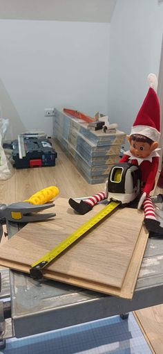 an elf sitting on top of a table with tools