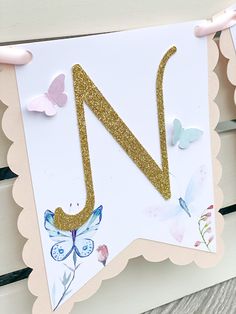 the letter n is made out of paper and has gold glitter on it's letters