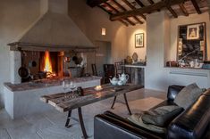 a living room filled with furniture and a fire place in the middle of an open floor plan