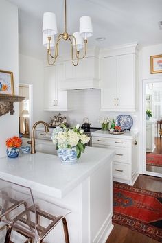 a kitchen with white cabinets and an island in the middle is decorated with blue and white dishes