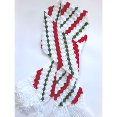 a white scarf with red, green and white stripes on it sitting on top of a table