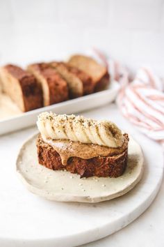 there is a piece of bread with bananas on it and some other food in the background