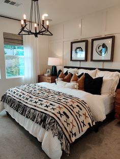 a bedroom with a large bed and two framed pictures on the wall