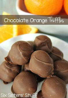 chocolate orange truffles on a white plate with an orange in the background