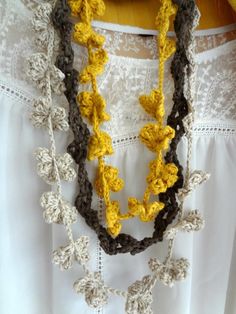 a crocheted necklace is hanging on a white shirt