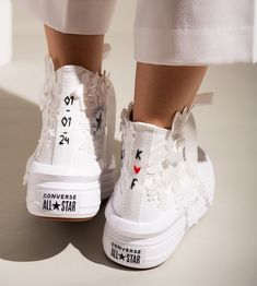 a pair of white shoes with hearts and arrows on them