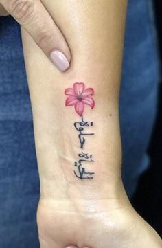 a woman's wrist with a flower on it and the words written in chinese