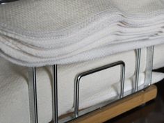 a close up of a bed with white blankets and metal bars on the bottom rail