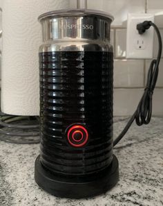 a black and silver coffee pot sitting on top of a counter