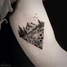 a black and white photo of a triangle with trees on it's side tattoo