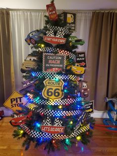 a christmas tree decorated with cars and lights in the shape of a race car is shown