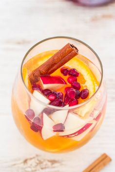 a glass filled with fruit and spices on top of a table