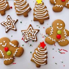 christmas cookies decorated with icing and sprinkles on a white tablecloth