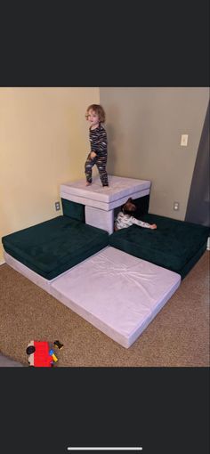 a little boy standing on top of a set of stairs in the middle of a room