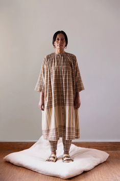 An airy, anti-fit muslin cotton dress that grazes the calf and gathers around the neck and shoulders. 3/4-quarter sleeves with hand-embroidered cuff details on silk. This Kaneer Dress is made from airy, anti-fit muslin cotton that grazes the calf and gathers around the neck and shoulders. This design includes 3/4-quarter sleeves with hand-embroidered cuff details on silk for added elegance and charm. Perfect for any fashion-forward individual seeking style and comfort. Mens Outerwear Fashion, Dress Over Pants, Visionary Fashion, Hand Woven Textiles, Fashion 2024, Cotton Muslin, Linen Trousers, Muslin Cotton, Drawstring Pants