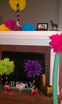 a fireplace decorated with tissue pom poms and streamers