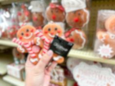 a person holding up a small piece of gingerbread in front of some other items