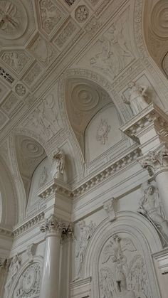 an ornately decorated ceiling in a white room with columns and carvings on the walls