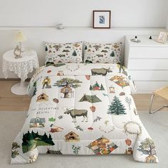 a bed with animals and trees on it in a room next to a white wall