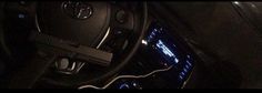 the interior of a car with an electronic device hooked up to it's steering wheel