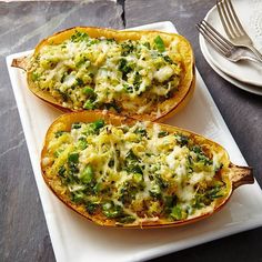 two stuffed squash halves on a plate with cheese and broccoli in the middle