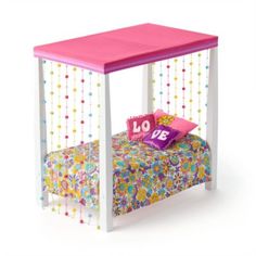 a toy bed with a pink canopy and polka dot bedspread on the bottom