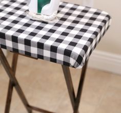 a black and white checkered table cloth with an ironing board on it