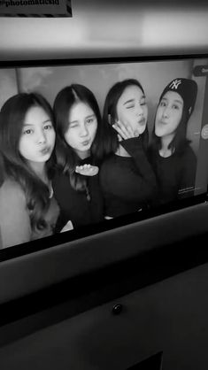 black and white photograph of four girls on the subway