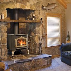 a living room filled with furniture and a fire place in the middle of it's fireplace