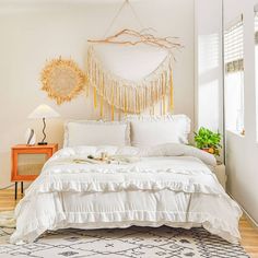 a white bed sitting in a bedroom next to a window