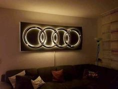 a living room with a couch and some lights on the wall above it that have audi emblems