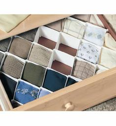 an open drawer with many different colors of fabric in it and the bottom section is made out of wood