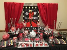 an assortment of candy and candies on display in front of a red drapes