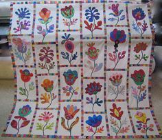 a quilt with flowers on it sitting on a table