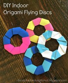 three origami flying discs sitting on top of a wooden table