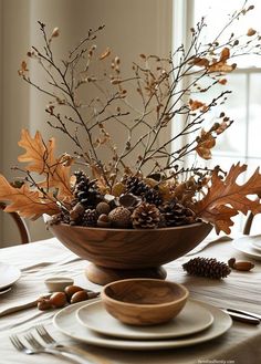 a wooden bowl filled with lots of leaves and pine cones on top of a table