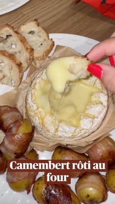 someone is dipping cheese on top of some breads and potatoes with other food items