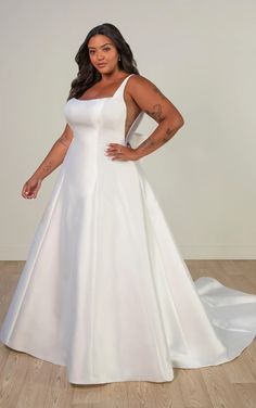 a woman in a white wedding dress posing for the camera with her hands on her hips