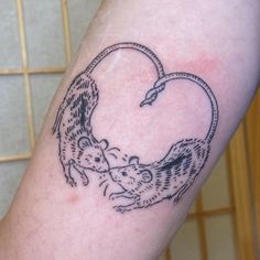 a tattoo on the arm of a person with a mouse in it's heart