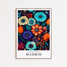 a colorful flower market poster hangs on the wall in front of a white frame with an orange, blue, and red floral arrangement