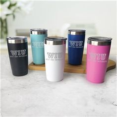 thermos are lined up on a tray with their names and sayings in different colors