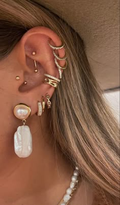 a woman's ear with three different types of piercings