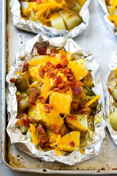 baked potatoes covered in cheese and bacon on a baking sheet