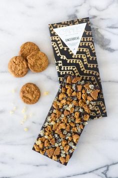 cookies and crackers sitting on top of a marble countertop next to a tie