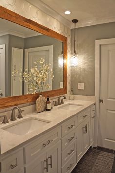 a bathroom with two sinks and a large mirror