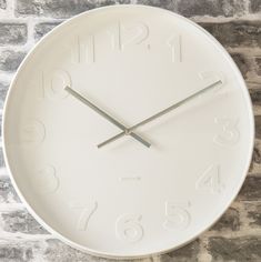 a large white clock on the wall with numbers