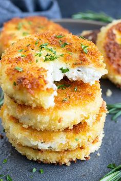 three crab cakes stacked on top of each other, with herbs sprinkled all over them