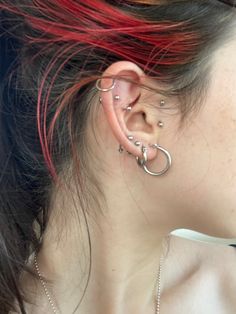 a woman with red hair and piercings on her ear